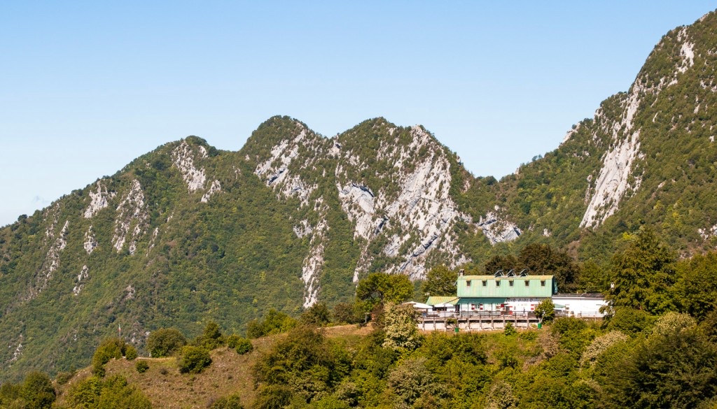Rifugio Pirlo allo Spino with its green roof below the peaks